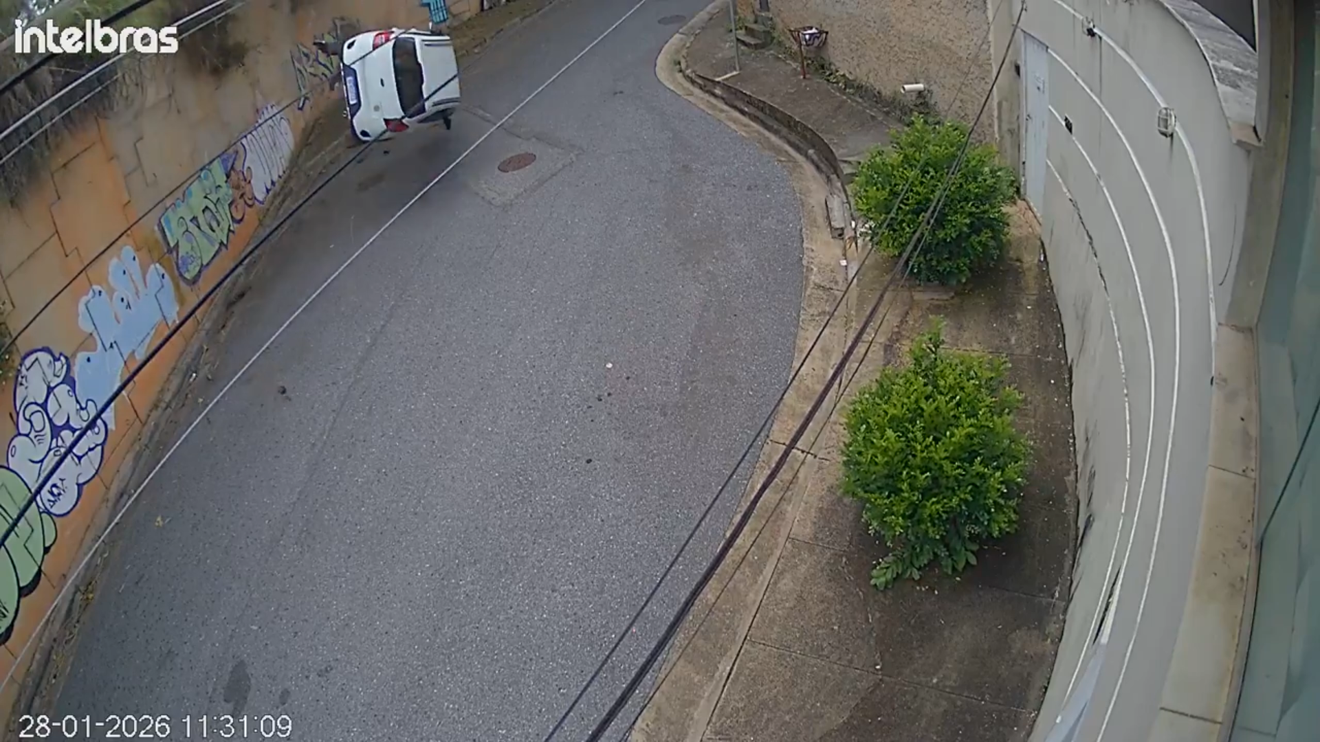 A wide frame from the video showing the car upside down after the fall, without visible injuries or close-ups.