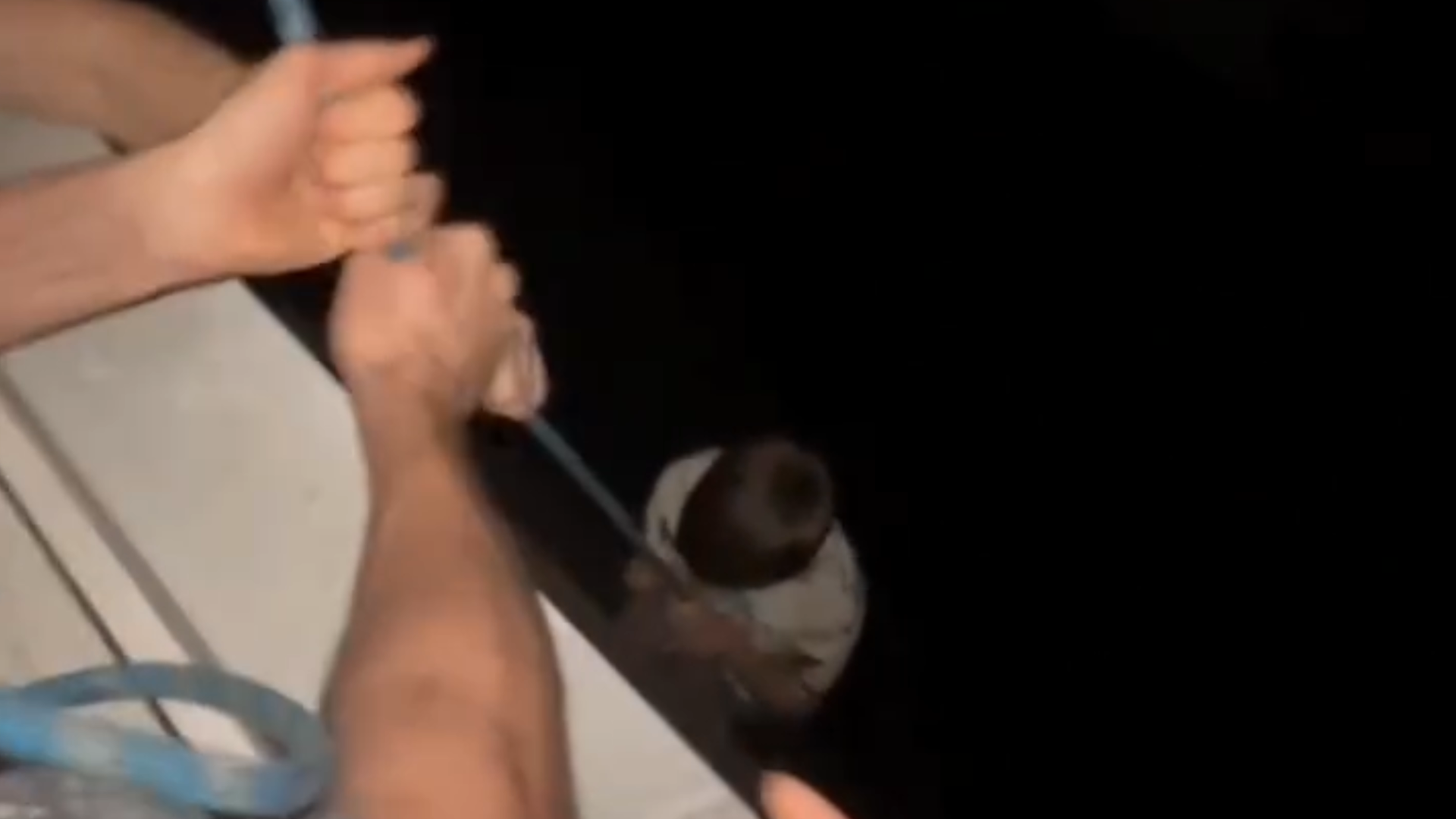 A still frame from the video showing the balcony exterior with the rope visible, avoiding close-up or distressing imagery.