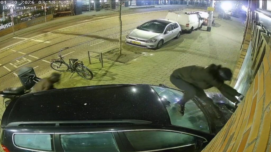 CCTV frame showing a car crashed into the shuttered entrance of a jewelry store on Nieuwe Binnenweg in Rotterdam at night.
